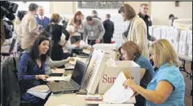  ?? HENRY TAYLOR / HENRY.TAYLOR@AJC.COM ?? Journalist­s make their way Thursday through the 1.4 million printed documents while scanning and uploading them, trying to discern their relevance to the City Hall bribery case in Atlanta.