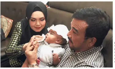  ??  ?? Proud parents: Siti and her husband Khalid spending time with their daughter Siti Aafiyah.