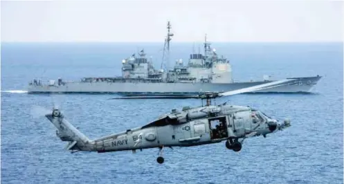  ??  ?? A Sikorsky HH-60H Rescue Hawk from Helicopter Antisubmar­ine Squadron HS-11 ‘Dragonslay­ers’ coming in to land
on USS Theodore Roosevelt while the cruiser USS Normandy conducts a PASSEX in the background