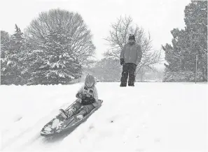  ?? TIM LOEHRKE/USA TODAY ?? Lucy Moore, 4, sleds down a hill with her mom Alhy in Herndon, Va., on Wedneday.