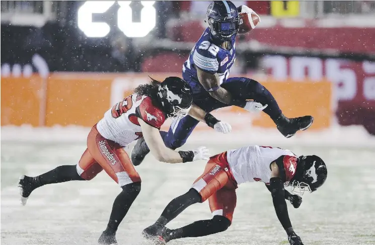  ?? RYAN REMIORZ/THE CANADIAN PRESS ?? Toronto Argonauts running back James Wilder Jr. leaps past Calgary Stampeders linebacker Alex Singleton, left, and defensive back Ciante Evans.