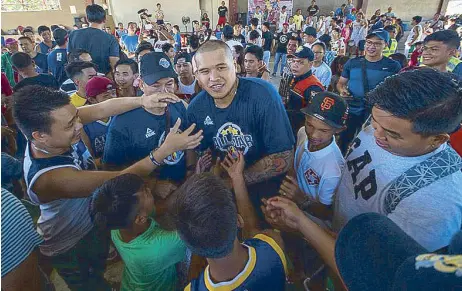  ??  ?? Fans mill around JR Quiñahan of the PBA All Stars as he hands out giveaways during the meet-and-greet of the PBA AllStar Weekend in Iloilo City.