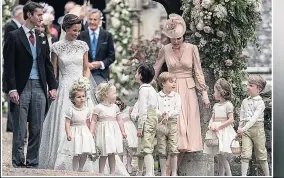  ??  ?? LITTLE BELTERS Pippa and James smile as pageboys and bridesmaid­s relax