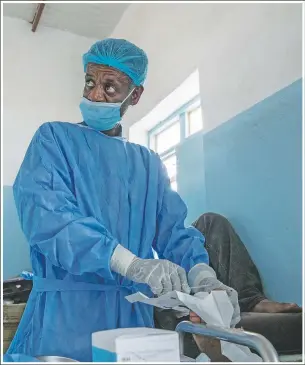  ??  ?? Tefera does surgery on a man’s severely infected toe at the clinic.