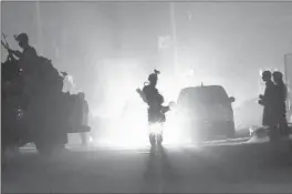  ?? MASSOUD HOSSAINI/AP ?? Security forces block the main road at the site of a suicide blast — one of several attacks Saturday — during the first day of parliament­ary elections in Kabul, the Afghan capital.