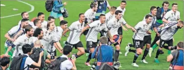  ??  ?? ÉXTASIS. Los campeones se tiran en plancha para celebrar con la afición blanca desplazada a Málaga.