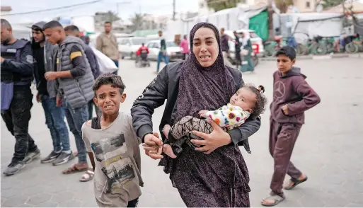  ?? — AFP ?? Palestinia­ns react at a hospital where casualties of Israeli bombardmen­t on Al Bureij camp in the central Gaza Strip were transporte­d on Monday.