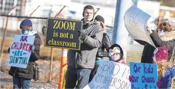  ?? APRIL GAMIZ PHOTOS| THE MORNING CALL ?? People hold signs and chant while cars pass by during a Reopen Our Schools rally held in Whitehall on Saturday afternoon.