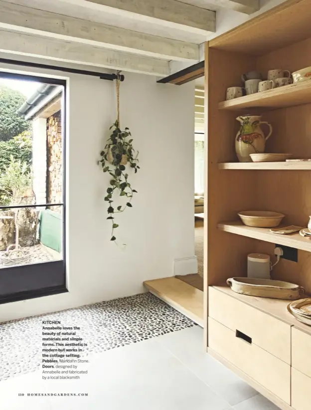  ??  ?? KITCHEN
Annabelle loves the beauty of natural materials and simple forms. This aesthetic is modern but works in the cottage setting. Pebbles, Mandarin Stone.
Doors, designed by Annabelle and fabricated by a local blacksmith