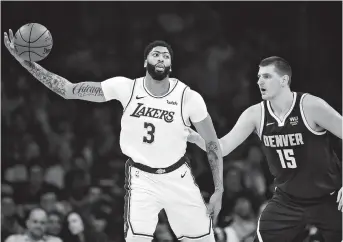  ??  ?? Los Angeles Lakers forward Anthony Davis controls the ball against Denver Nuggets center Nikola Jokic during the first half of their NBA clash at Staples Center in Los Angeles on Sunday. The Nuggets won 128-104. — Reuters