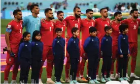  ?? ?? Iran’s players stand in silence as the Islamic Republic’s national anthem plays at Khalifa Internatio­nal Stadium in Doha. Photograph: Neil Hall/EPA