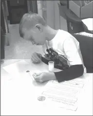  ??  ?? Measuremen­t: In Connie Hammett’s class, Junction City Elementary student Hunter Wood works to find out how many drops of water and soapy water a penny would hold.