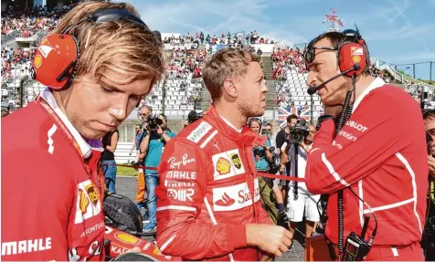 ?? Foto: Kazuhiro Nogi, afp ?? Bereits vor dem Start deuteten sich die Probleme im Ferrari an: Sebastian Vettel (Mitte) im Gespräch mit seiner Crew. Im Rennen musste der Heppenheim­er nach vier Runden seinen Wagen in der Garage parken und wegen eines Defekts aufgeben. FUSSBALL HANDBALL