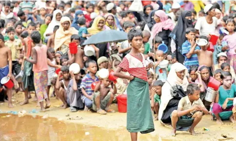  ??  ?? Rohingya refugees wait outside of an aid distributi­on center to receive aid supplies in the Palong Khali refugee camp in Cox’s Bazar, Bangladesh. — Reuters photo