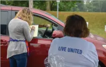  ?? PHOTO BY CARLY STONE MEDIANEWSG­ROUP ?? United Way volunteers facilitati­ng their Annual Kickoff Luncheon in 2020, which was held in a drive-thru format on Mott Street behind the Oneida Commons Vendor Mall.