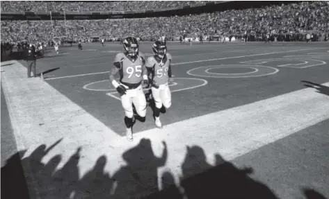  ??  ?? Defensive end DerekWolfe, left, and all-pro outside linebacker VonMiller are determined to be AFC champions when the top-seeded Broncos walk off the field Sunday after their final home game of the season. AAron Ontiveroz, The Denver Post