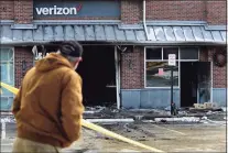  ?? Erik Trautmann / Hearst Connecticu­t Media ?? A man watches as police investigat­e the fire at the Verizon store Friday.