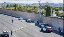  ?? ?? Yellow crimescene tape stretches across the northbound lanes of the 55 Freeway in Orange as investigat­ors look for evidence on May 21, 2021. No bullet casings were found.