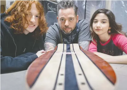  ?? DAVE SIDAWAY ?? Dan Mckay and his children Harley, 16. and Daisy-jo, 12, work together to build skateboard­s after Mckay's previous career as a tour manager for bands like Eagles of Death Metal, AWOLNATION and Five Finger Death Punch came to a sudden halt with the COVID-19 pandemic.