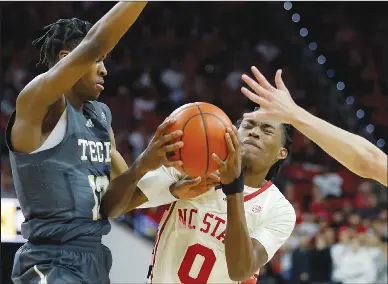  ?? Associated Press ?? Driving: North Carolina State's Terquavion Smith (0) drives against Georgia Tech's Miles Kelly, left, and Lance Terry during the second half of an NCAA college basketball game Saturday in Raleigh, N.C.