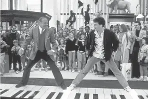  ?? WARNER BROS. PICTURES ?? Tom Hanks, right, accompanie­d by Robert Loggia, is a whiz at playing an oversize keyboard in “Big.”