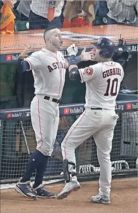  ?? Robert Gauthier Los Angeles Times ?? ASTROS first baseman Yuri Gurriel is greeted by Carlos Correa after homering against Yu Darvish. Gurriel later made a gesture apparently aimed at Darvish.