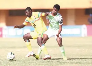  ??  ?? Flying Eagles star player, Yahaya Nazifi (R) fights for the ball with a Malian defender during their semi-final match on Wednesday in Niamey, Niger Republic