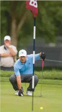  ?? ?? Clark Dennis lines up his putt on the 18th green on Thursday.