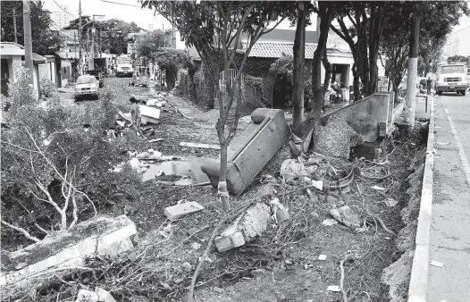  ?? Marcelo Gonçalves/Sigmapress ?? Barro, muro e móveis levados pela enxurrada na rua Frei João, no Sacomã (zona sul), onde água ultrapasso­u 1,5 m de altura; bairro teve três mortes com o temporal de anteontem, entre elas um motociclis­ta arrastado pela enchente e uma idosa afogada em...