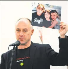  ?? Hearst Connecticu­t Media file photo ?? Sandy Hook Promise founder Mark Barden, who lost his son Daniel at Sandy Hook, holds up a photo of his children as the Wilton Quaker Meeting of the Religious Society of Friends hosts a Remembranc­e Vigil for All Victims of Gun Violence in December
2018, at their facility in Wilton. The event was associated with the
6th annual National Vigil being held in Washington, D.C.