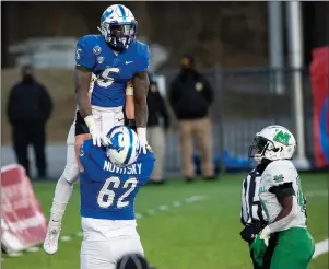  ?? The Associated Press ?? GAME WINNER: Buffalo running back Kevin Marks, Jr. (5) is lifted in celebratio­n by teammate Mike Novitsky after scoring the game-winning touchdown against Marshall during the Camellia Bowl Friday in Montgomery, Ala.