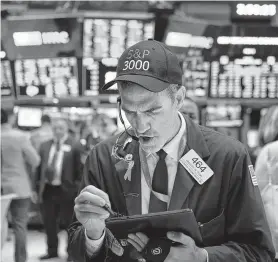  ?? Spencer Platt / Getty Images ?? Traders work the floor of the New York Stock Exchange. The Dow rallied Wednesday, and the S&P 500 crossed 3,000 points for the first time.