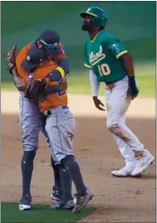  ?? ASHLEY LANDIS — THE ASSOCIATED PRESS ?? Houston’s Jose Altuve, center, celebrates with Carlos Correa in front of the Athletics’ Marcus Semien after the Astros defeated the Athletics in Game 2 of the ALDS.