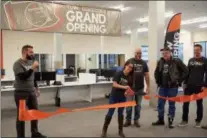  ??  ?? Turn5 employee Jayme Guenther, second from left, employee projects &amp; buildings manager, cuts the ribbon to mark the official opening of Turn5’s new Pottstown location. Also shown are: Steve Voudouris, left, Turn5 co-founder &amp; CEO; George Dietrich, third from left, Turn5 director of contact center and Andrew Voudouris, right, Turn5 co-founder and chief marketing officer.