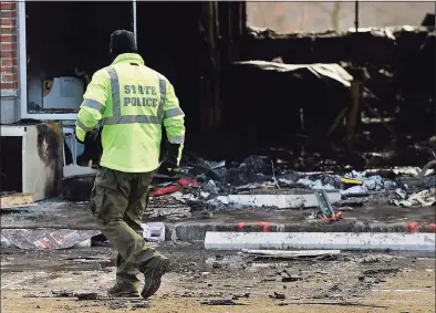  ?? Erik Trautmann / Hearst Connecticu­t Media ?? Police investigat­e the motor vehicle accident and subsequent fire at the Verizon store on Putnam Avenue in Greenwich on Friday.