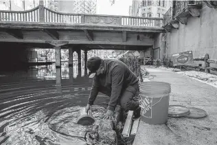  ?? Jessica Phelps / Staff photograph­ers ?? Henry Rodriguez fills buckets from the River Walk so Granada Home residents could flush toilets. Warnings about about power outages would have allowed Texans to prepare.