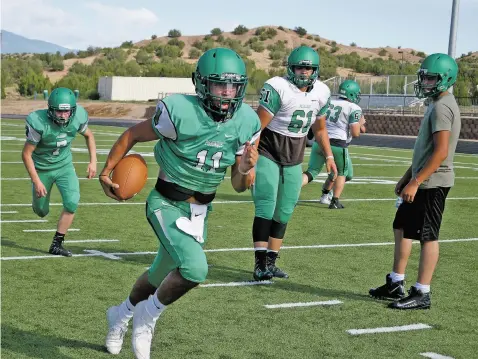  ?? PHOTOS BY MATT DAHLSEID/THE NEW MEXICAN ?? Quarterbac­k Devonn Holmes finds an opening during practice Monday at Pojoaque Valley High School.