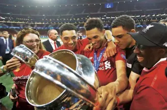  ??  ?? With his family, holding the Champions League trophy in Madrid, June 2019