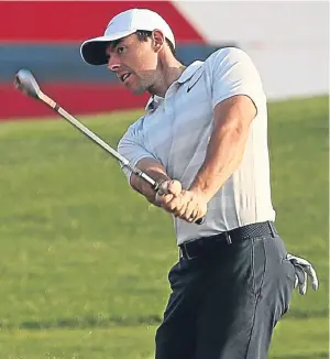  ?? Picture: Getty. ?? Rory Mcilroy chips on to the 17th green during a practice round in Abu Dhabi.