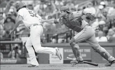  ?? CHRIS LEE/TRIBUNE NEWS SERVICE ?? Cincinnati Reds catcher Devin Mesoraco tags out St. Louis Cardinals' Michael Wacha on a sacrifice bunt in the fourth inning during the Cardinals' 8-2 win on Monday in St. Louis.