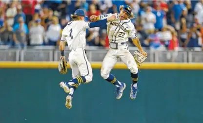  ?? AP PHOTO/JOHN PETERSON ?? Michigan right fielder Jordan Brewer, right, celebrates with teammate Jack Blomgren after the Wolverines defeated Vanderbilt 7-4 in Game 1 of the College World Series on Monday in Omaha, Neb.