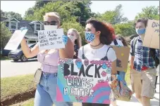  ?? LYNN KUTTER ENTERPRISE-LEADER ?? Gracie Marler, left, and Natalia Culley, both 10th graders at Prairie Grove High School, organized a peaceful protest in support of the Black Lives Matter movement through an Instagram post. About 15 people walked from Battlefiel­d State Park to Mock Park in downtown Prairie Grove on June 4, carrying signs and waving to vehicles passing by.