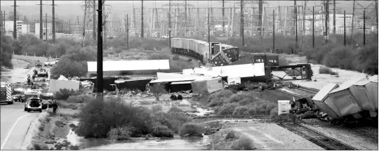  ?? KELLY PRESNELL/ARIZONA DAILY STAR VIA AP ?? A UNION PACIFIC TRAIN DERAILED ON THE EAST SIDE OF INTERSTATE 10 JUST NORTH OF TWIN PEAKS ROAD in Marana on Tuesday. Authoritie­s say heavy rain from a monsoon storm in southern Arizona has caused the derailment. Northwest Fire District officials say about 40 cars went off the rails around 3 p.m. Tuesday as a strong storm was going through the Marana area near Interstate 10.