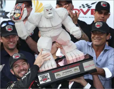  ?? MEL EVANS — THE ASSOCIATED PRESS ?? Martin Truex Jr., left front, holds up the trophy as he celebrates in Victory Circle after winning Sunday’s race at Dover Internatio­nal Speedway in Dover, Del. Kyle Busch (18) was second.