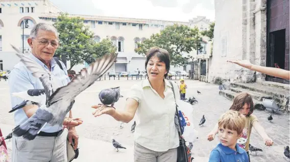  ??  ?? ► Sandra Ramírez juega con unas palomas en una plaza de La Habana, en septiembre de 2012.