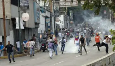  ?? RAMON ESPINOSA, THE ASSOCIATED PRESS ?? Opposition supporters and students clash with soldiers and riot police during a protest Monday in the Altamira neighbourh­ood of Caracas. Tensions are high after Sunday’s presidenti­al election, which Nicolas Maduro won by a narrow margin.