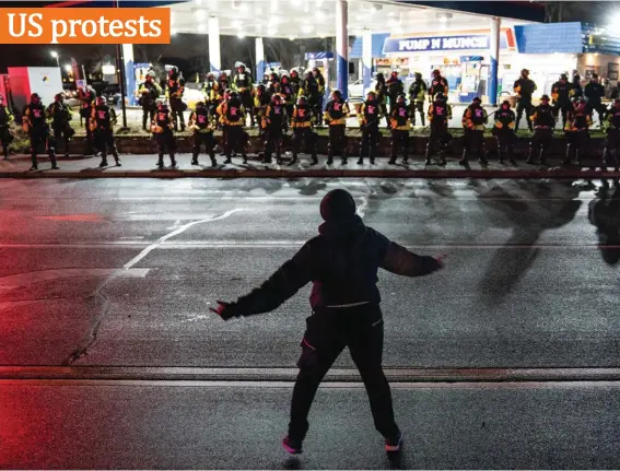  ?? Photo: AP ?? A demonstrat­or heckles authoritie­s who advanced into a gas station after issuing orders for crowds to disperse during a protest against the police shooting of Daunte Wright, late Monday, in Brooklyn Center, Minnesota, USA.