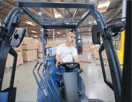  ?? Irfan Khan Los Angeles Times ?? ALBERTO LOPEZ drives a forklift at Ontario’s Pacific Mountain Logistics, which has tripled its workforce in the last three years.