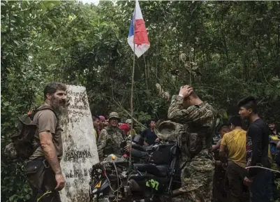  ??  ?? The team stops briefly to celebrate reaching Palo de Las Letras, the border marker between Panama and Colombia.