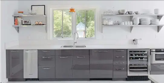  ?? PHOTOS: JOHN MCDONNELL/WASHINGTON POST ?? The Ikea kitchen offers numerous work stations for meal preparatio­n. The open stainless shelving came from a restaurant-supply store.